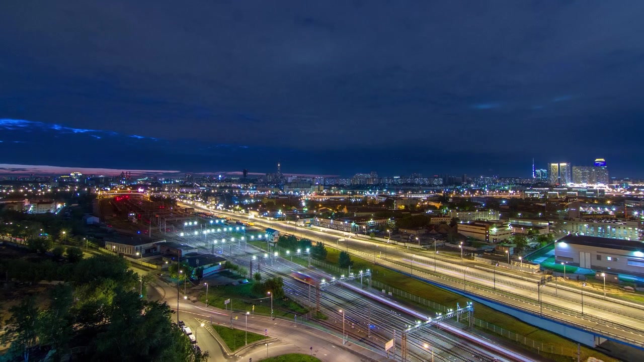 Moskova timelapse, yöllinen ilmakuva ylhäältä kolmannesta liikennekehätieestä ja Moskovan kehäteiden keskiosasta, liikenne, autonvalot, rautatie junineen panoraama katolta.