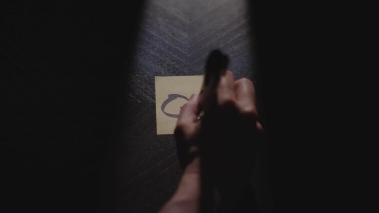 Q3 written on a Sticky Note with a sharpie and placed on a table under dramatic lighting
