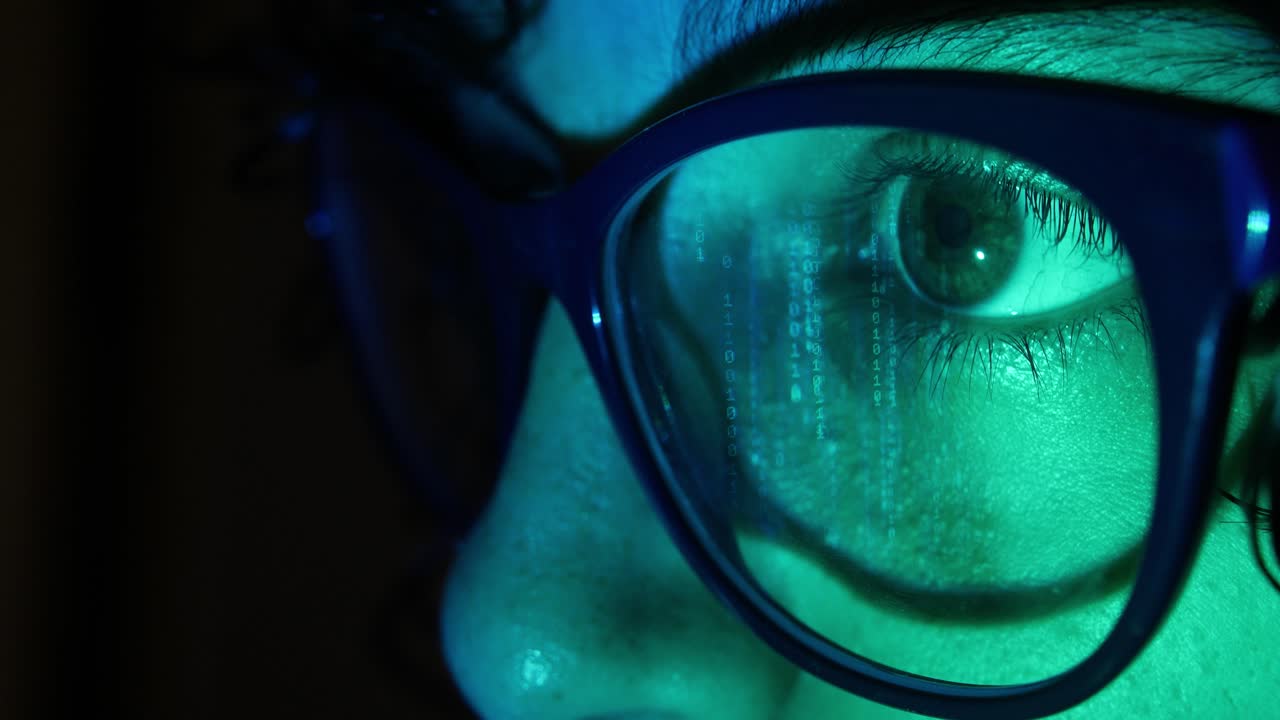 Close-up of Eye and Glasses Reflecting Binary Code