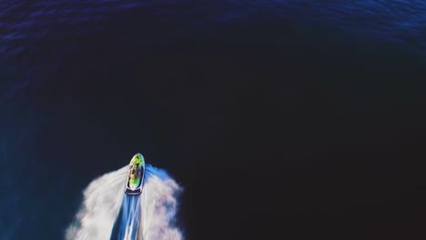 jetski on the mediterranean sea, birdseye view tilting up to reveal the coastline of the south of spain