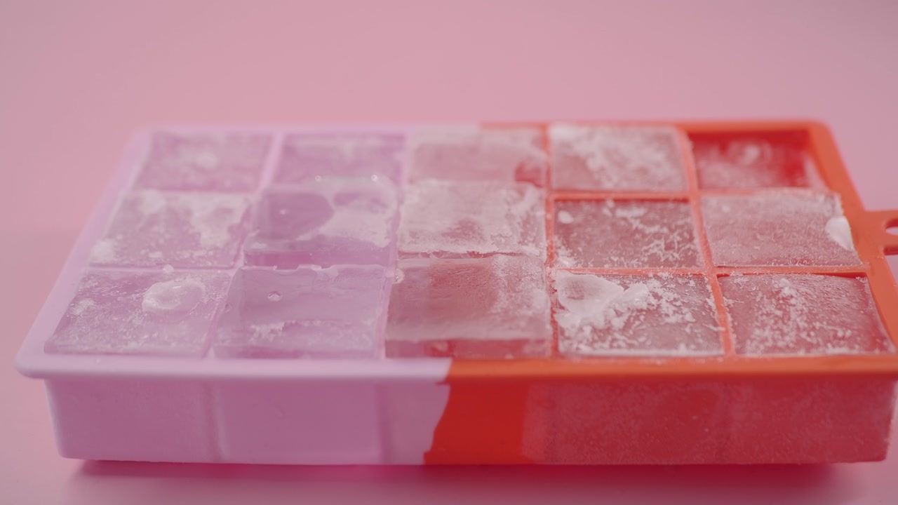 Close-up of Ice Cubes in a Colorful Ice Tray on Pink Background