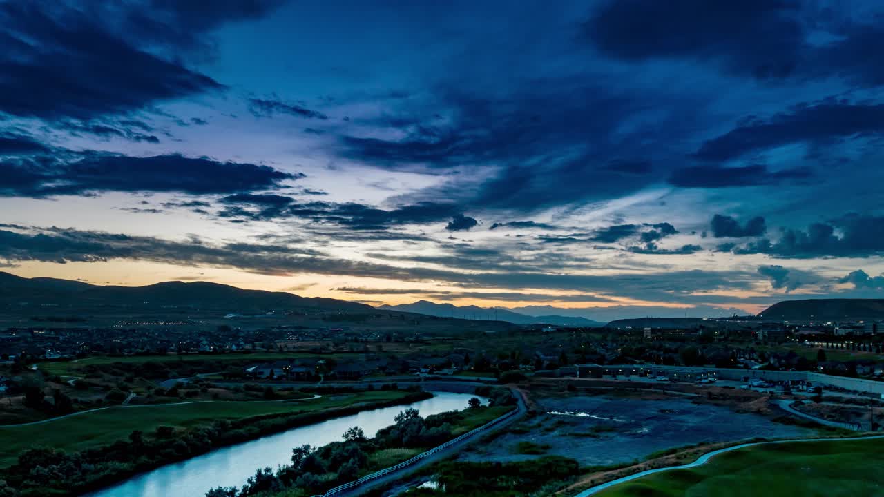 Lehi, Utah at Thanksgiving Point Golf Course and neighborhood along the Jordan River during a colorful sunset - pullback aerial hyper lapse