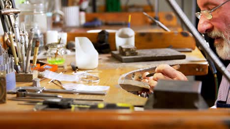 goldsmith working at desk in workshop 4k