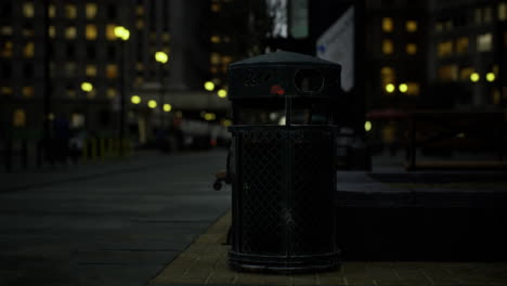 trash bin illuminated by street lights in urban city after dark