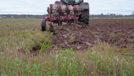 vista trasera del tractor agrícola arando la tierra