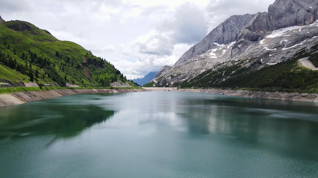 Lac alpin reflétant la sérénité des Dolomites près de la Marmolada par une calme journée d'été.