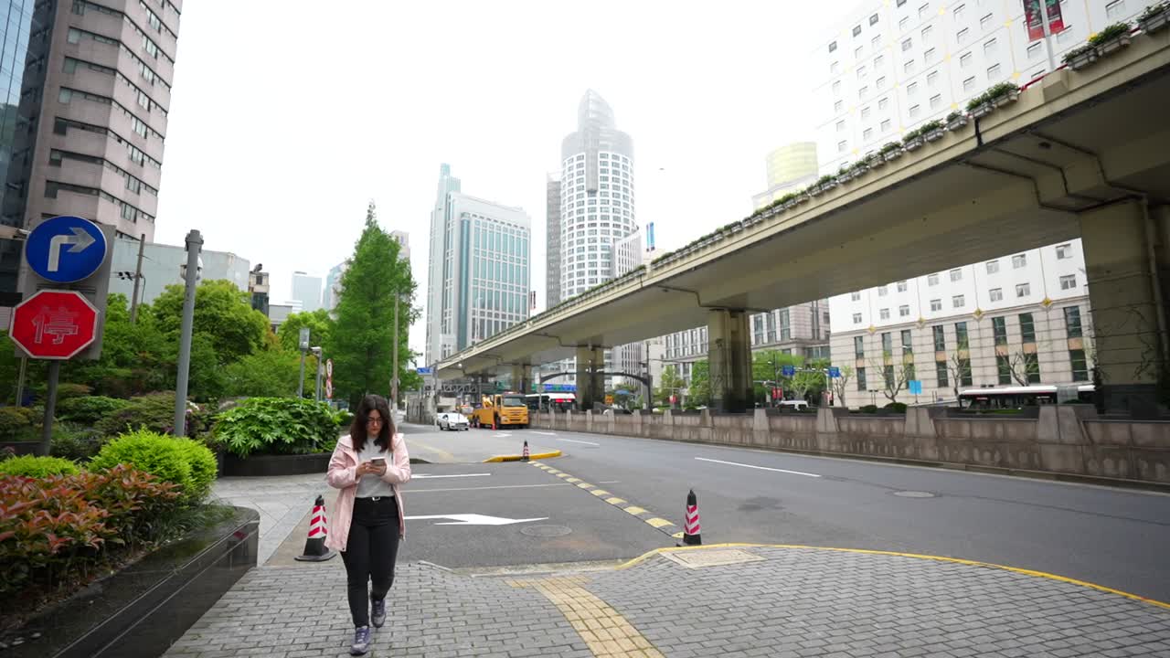 Slow motion of a woman walking along an empty Shanghai street early morning with soft light. Shanghai, China