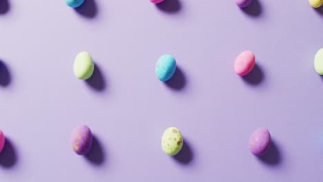 Close-up-of-multiple-colorful-easter-eggs-on-purple-background