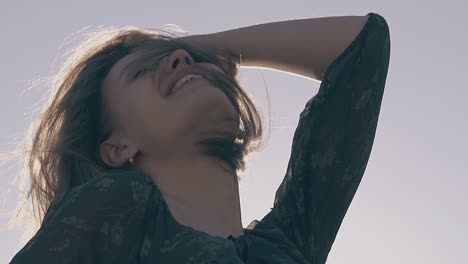 joyful-woman-poses-at-sunlight-on-windy-day-slow-motion