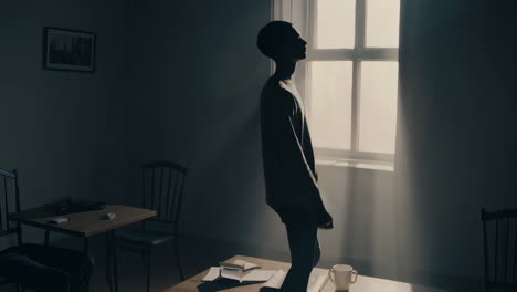 man contemplating at a window