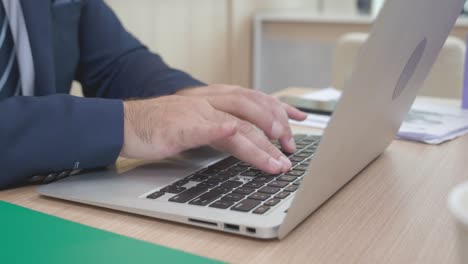 closeup hands of business man using laptop computer planning for success in modern office, businessman typing on notebook with confident, executive or manager working, business concept.