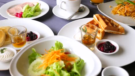 breakfast in hotel or resort. thai cuisine. close-up view of food on table in restaurant or cafe. coffee cup, orange juice, pancakes, waffles, salad, cold cut. lunch, branch or dinner concept