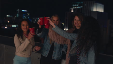 beautiful group of women friends enjoying rooftop party at night drinking making toast to friendship celebrating togetherness