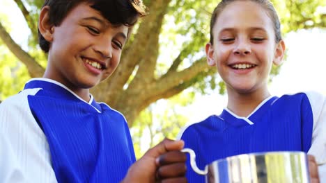 Kids-holding-winner-trophy-in-park