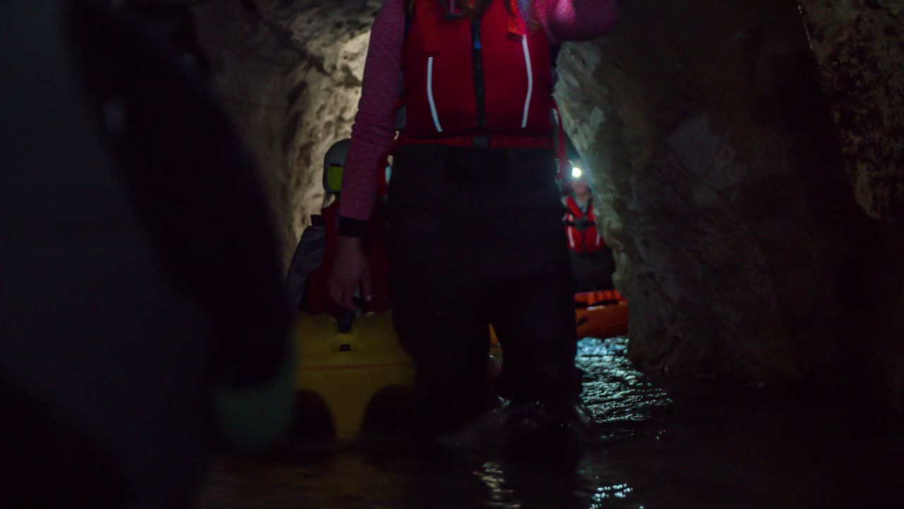 어두운 지하 광산 투어에서 여성이 카약을 옮기는 것을 돕고 있어요
