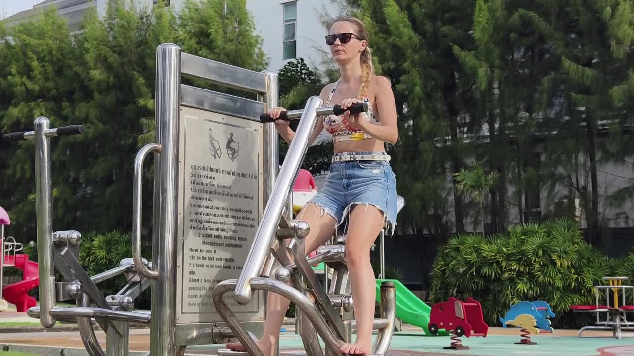 공원 에서 운동 기기 를 이용 하여 야외 에서 운동 하는 여자