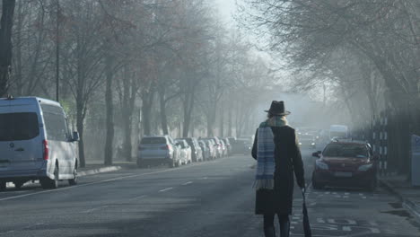 woman walks on side of road towards incoming cars