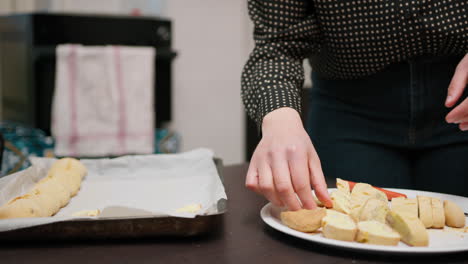 a woman distributes cantucci typical tuscany biscuits in a baking dish