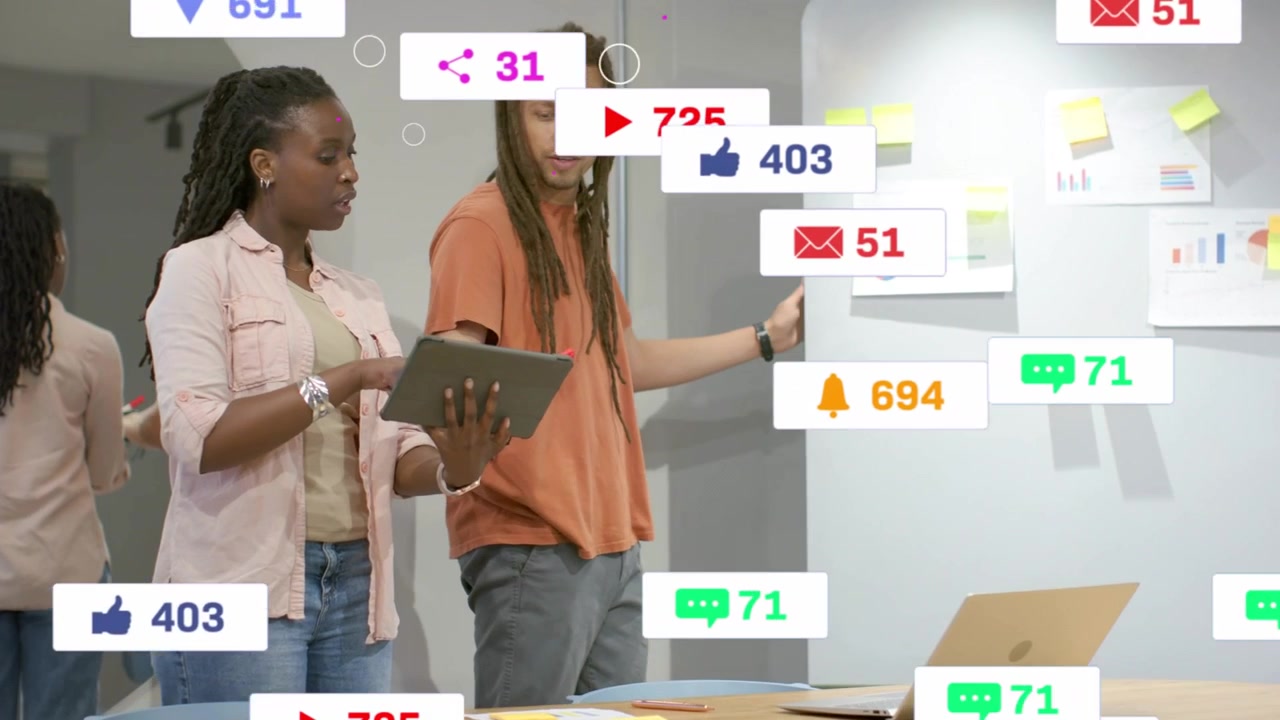 Two coworkers looking at tablet, social badges floating, obscuring then fading, planning marketing