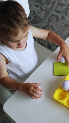 toddler playing with eggs