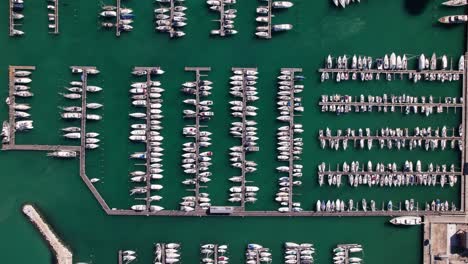 Aerial-top-down-view-of-many-yacht-boat-moored-in-a-harbour,-background