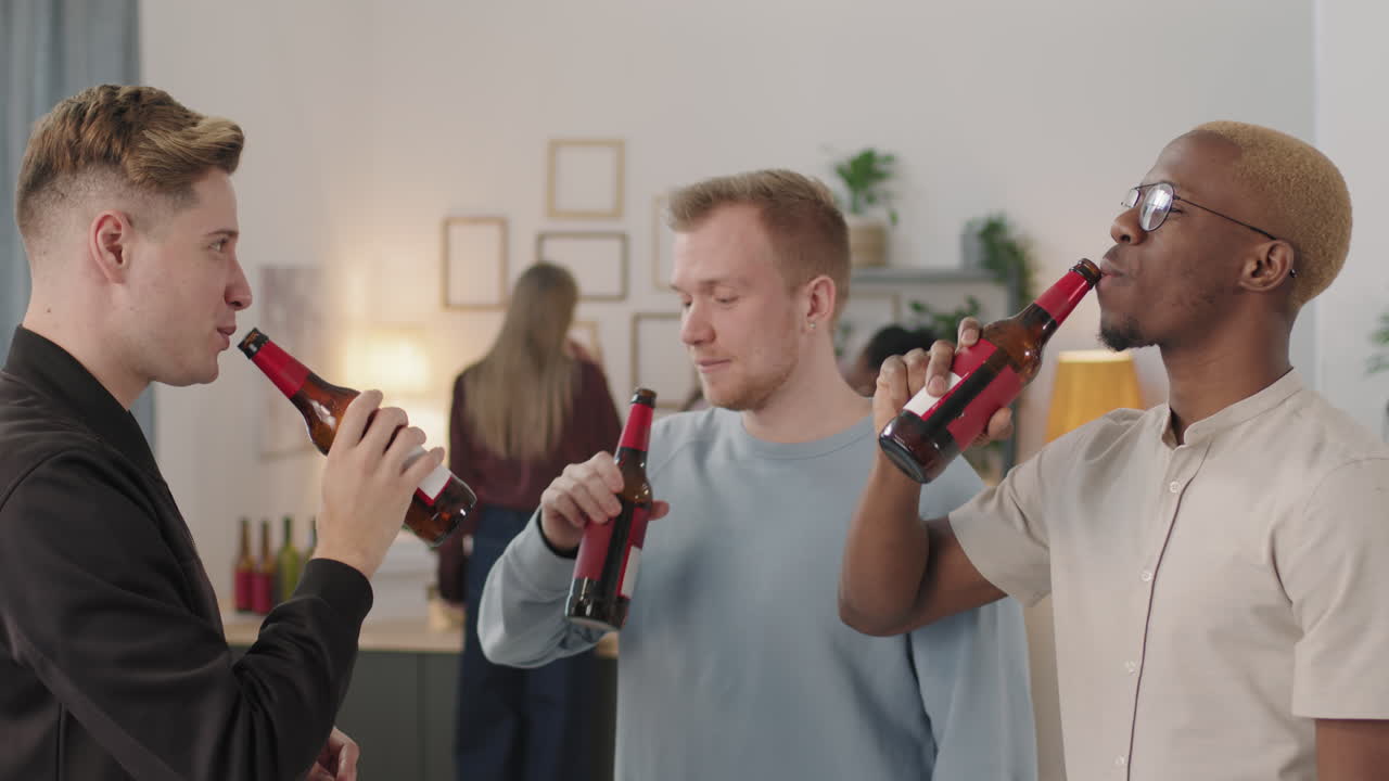 Tre menn som drikker øl på husfest