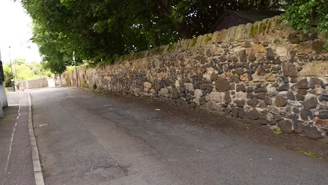 a quiet street with stone walls