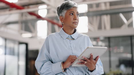 Thinking-business-woman-with-tablet-in-modern