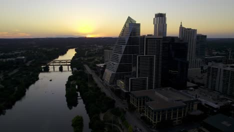 hermosa puesta de sol detrás del río colorado y los rascacielos de austin en estados unidos - vista aérea