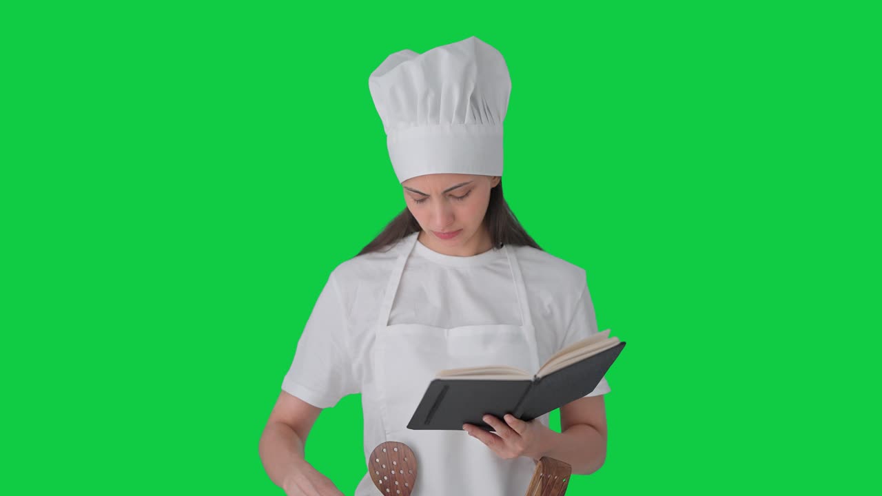 chef profesional india haciendo comida a partir de un libro de recetas pantalla verde