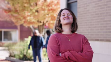 Mujer-Joven-Retrato-Auténtico-Sonriendo-Cruzando-Los-Brazos-Caída-Agradable-Pequeña-Ciudad