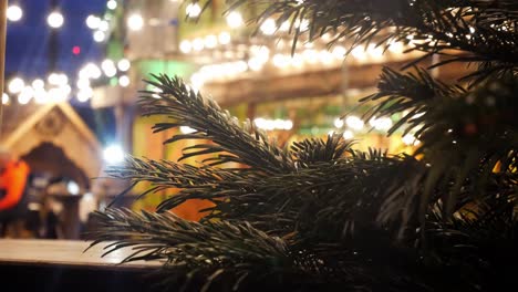 christmas tree pine needles close up shallow dof illuminated christmas market night party dolly left