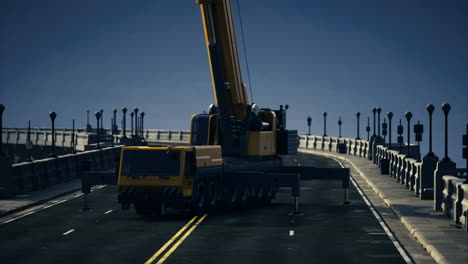 construction crane lifts heavy load on a busy urban bridge at dusk