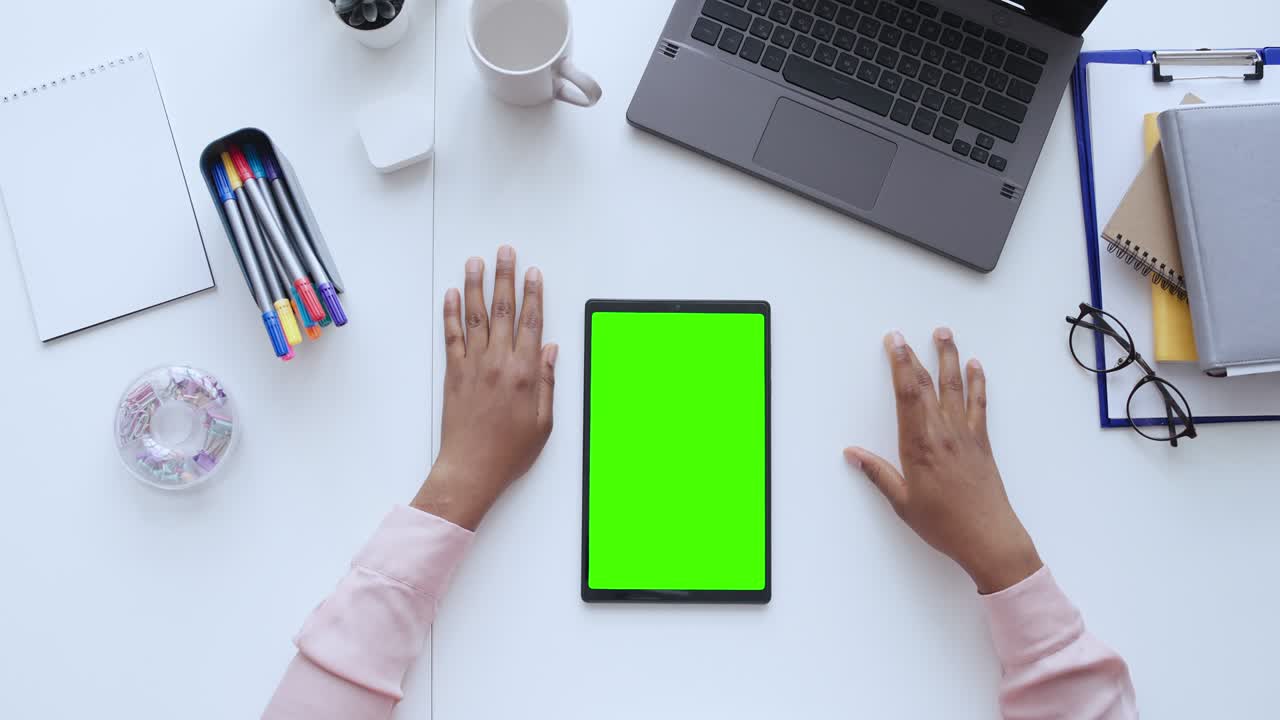 Vista dall'alto di una donna che guarda un video su tablet con schermo verde, app online.