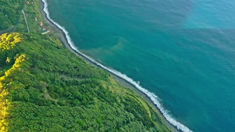 Lush-coastal-cliffs-and-blue-ocean-waves-in-miraduros-ponta-da-madrugada,-azores,-aerial-view