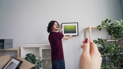 couple hanging picture in new home
