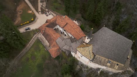 Drone-circling-over-rooftop-of-San-Romedio-sanctuary-of-Predaia,-Trentino-region-of-northern-Italy