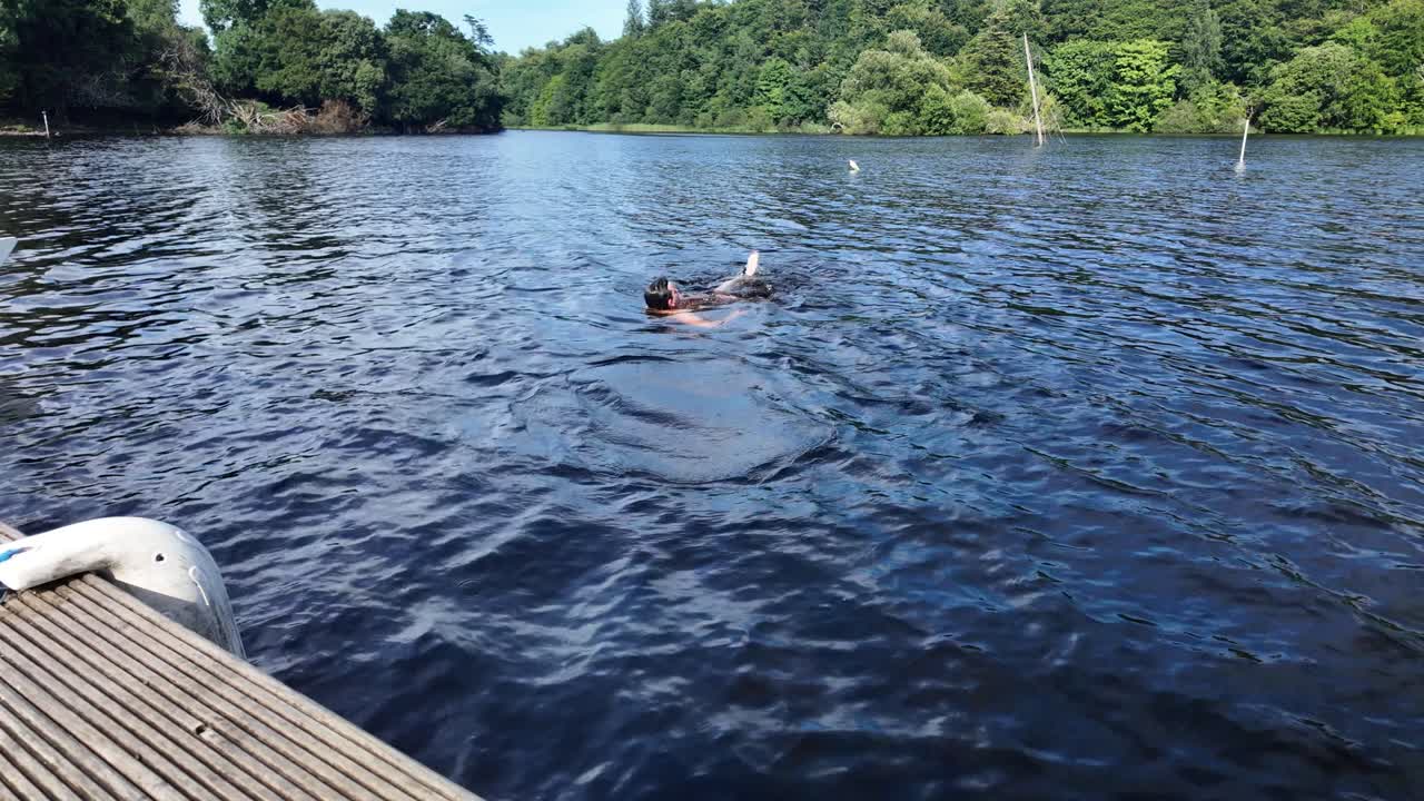Young man dives from Wooden Jetty into Clear Lake Water