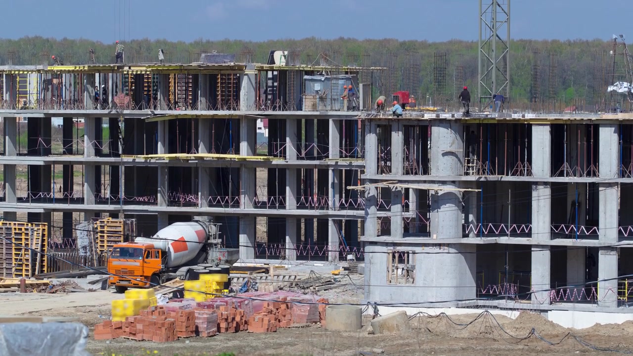 Large construction site with buildings under construction and multi-storey residential homes timelapse. Concrete mixer in action. Housing renovation concept. Crane during formworks