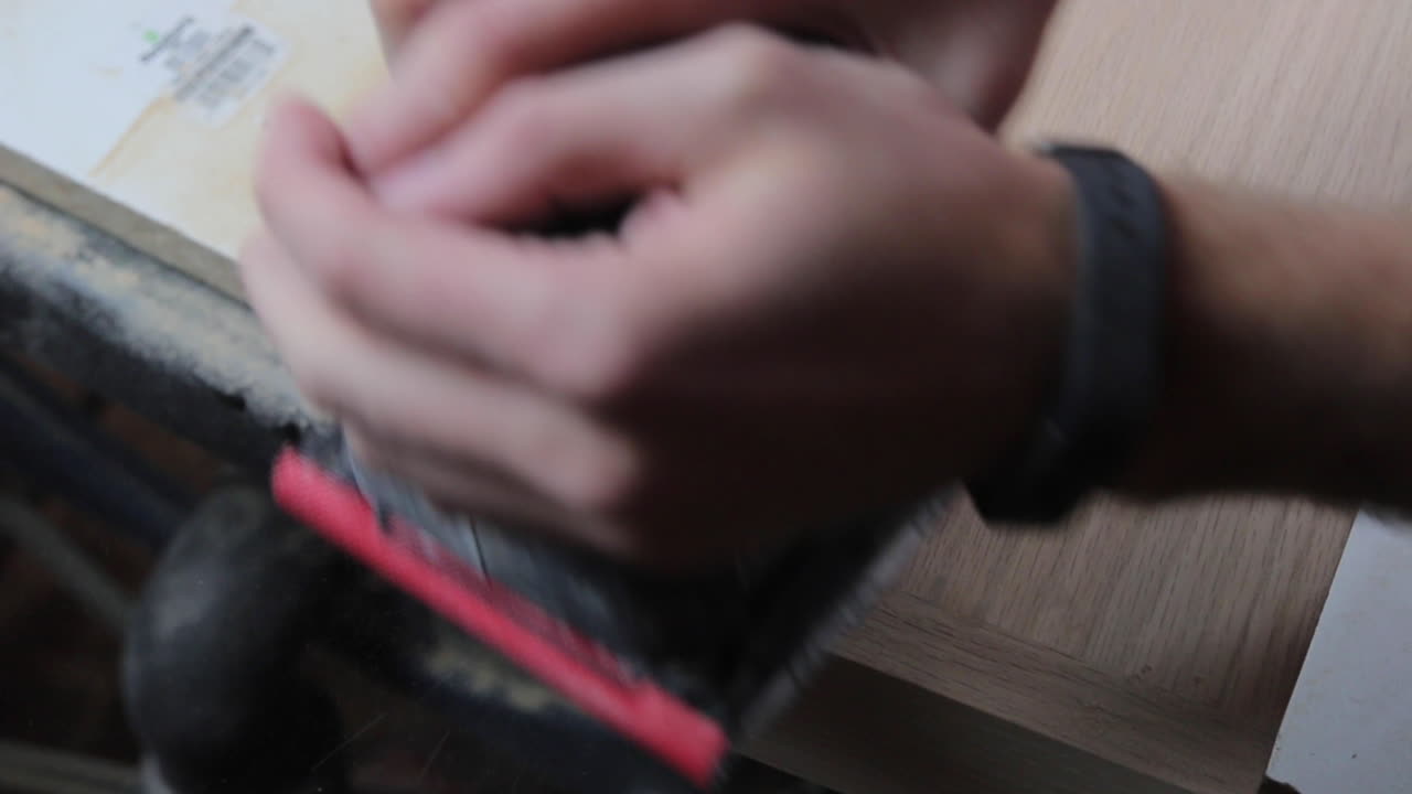 окончательная шлифовка деревянной шпатлевки на деревянных плавающих полках для подготовки к окрашиванию и подвешиванию в отремонтированной ванной комнате