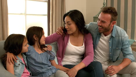 familia feliz hablando en el sofá
