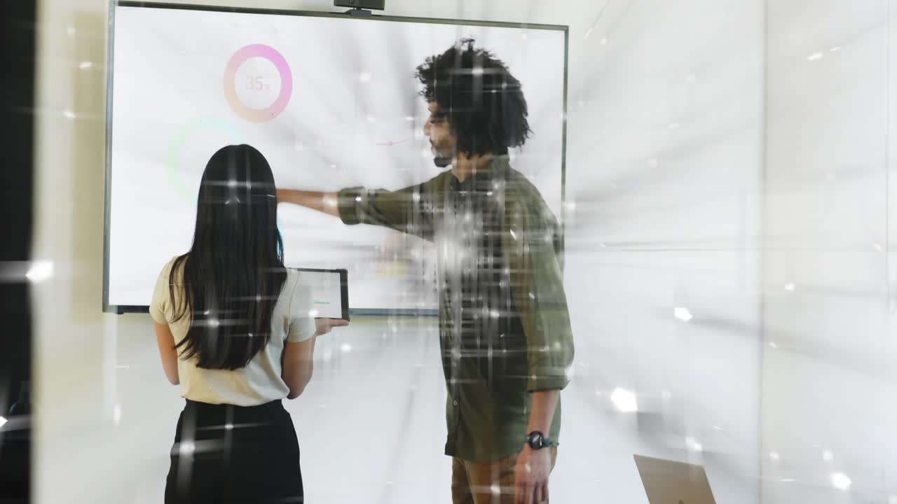 Woman using tablet and man pointing, updating circular business chart during review with streaks