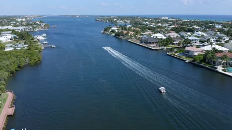 Disparo-De-Un-Dron-Mirando-Al-Norte-Desde-El-Puente-Levadizo-Sobre-El-Canal-Intercostero-En-Boynton-Beach,-Florida,-Con-Un-Barco-De-Recreo-En-La-Distancia