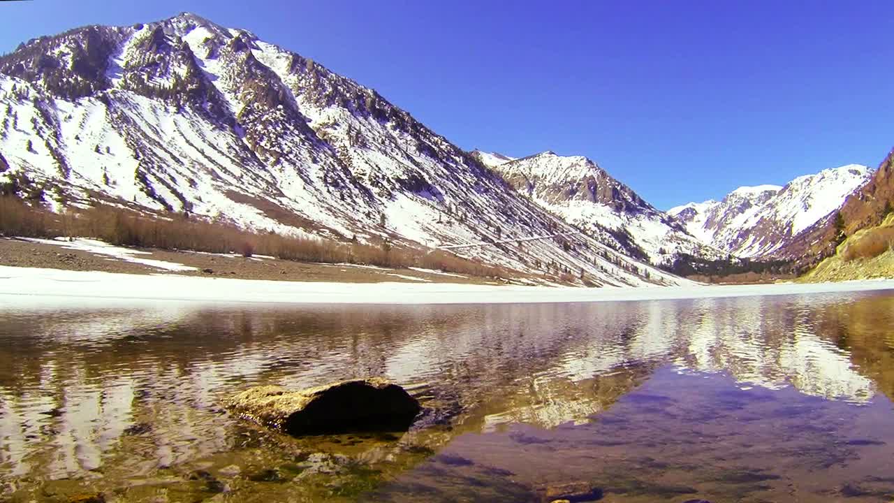 카메라는 아름다운 고산 호수의 물을 가로질러 움직입니다.