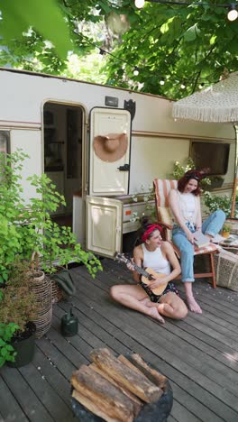 two women enjoying a summer vacation in a campervan on a wooden patio.