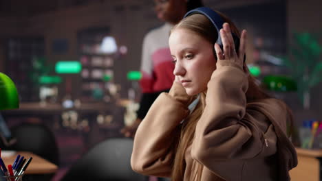vertical video female student listening to favorite songs and solving a school assignment