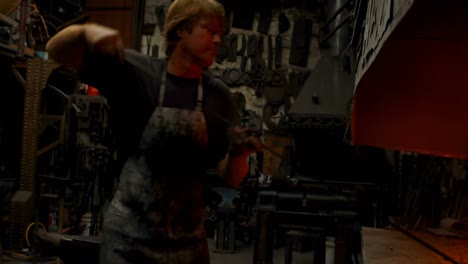 herrero calentando una varilla de metal en el fuego 4k