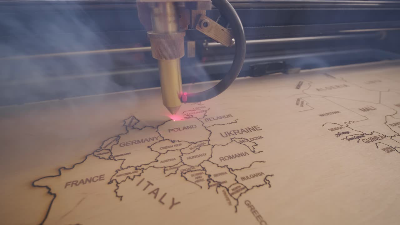 la máquina de corte por láser cnc corta el mapa del mundo en tabla de madera y contrachapado