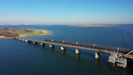 a high angle shot of a nyc subway train crossing over the bay in queens, ny