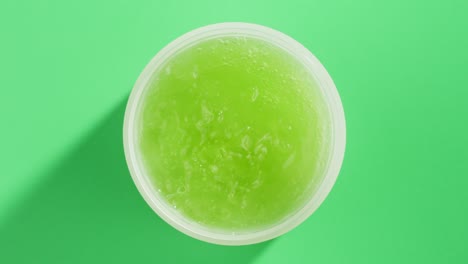 fresh ripe avocados with cream and essential oil on green background with mint mentol, make up cosmetics